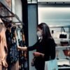 woman in black long sleeve shirt standing in front of clothes