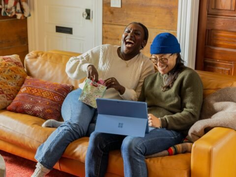 a person sitting on a couch with a laptop