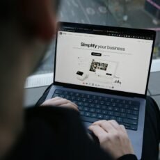 A man sitting on a bench using a laptop computer