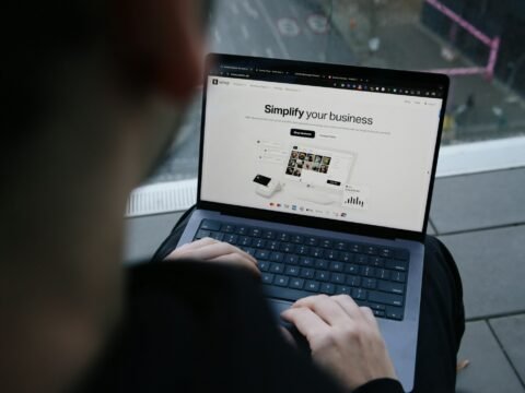 A man sitting on a bench using a laptop computer