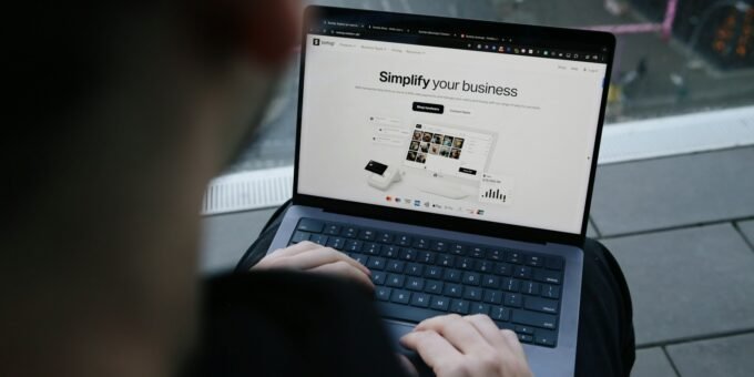 A man sitting on a bench using a laptop computer